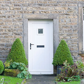Decorative topiary trees in pots by front door